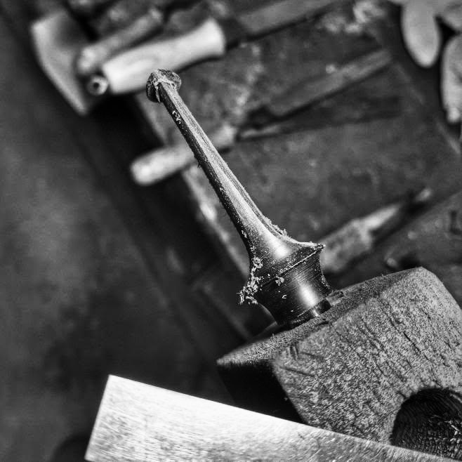 Frisch gedrehtes Mundstück-Rohteil auf einem Holzklotz in der Werkstatt, Schwarz-Weiß-Aufnahme